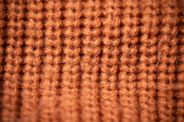 Orange wool scarf background texture. Macro photo with selective focus.