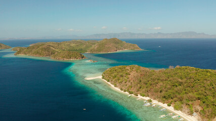 aerial view tropical islands with blue lagoon, coral reef and sandy beach. Palawan, Philippines. Islands of the Malayan archipelago with turquoise lagoons.