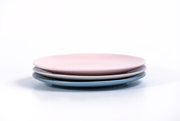 Stack of three colorful empty plates isolated on white background, side view. Navy Blue, Grey and Pink empty plates collection