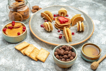 Homemade pancakes biscuits honey and chocolate biscuits in a glass jar on blue background