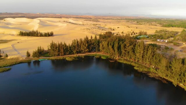 Aerial view of Bau Trang lake (a beautiful landscape, raw of automobiles with blue sky in desert, beautiful landscape of white sand dunes), the popular tourist attraction place in Mui Ne, Vietnam.