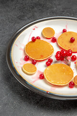 front view yummy little pancakes with red berries on a dark background fruit dessert sweet