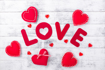 Word Love and red hearts on white wooden background Red textile letters. Valentines Day greeting card