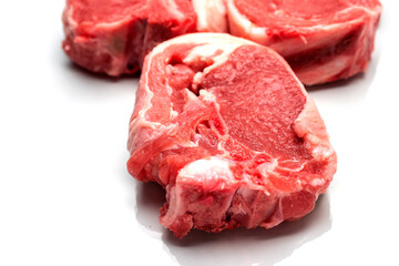 Three raw uncooked lamb loin chops on a white background, isolated, Meat industry product