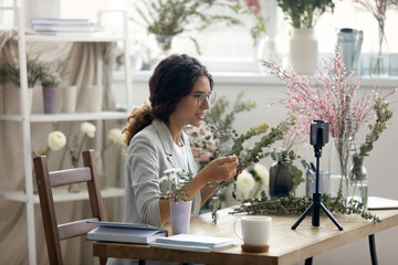 Do it yourself. Enthusiastic young woman giving professional course webinar by flower arranging....