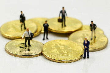 Miniature people : Businessman with Cryptocurrency Bitcoin coins virtual money and dollars,will growth up in the future bitcoin investment