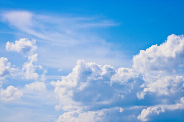 Fototapeta na wymiar Cumulus and cirrus clouds in the blue sky. Atmospheric phenomenon, weather, summer.
