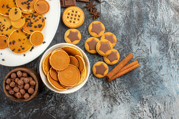 close up view of pancakes with cereals and cookies with cinnamons on grey ground