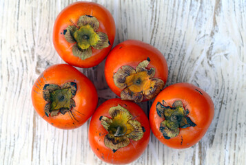 sobre a mesa estão caquis maduros.