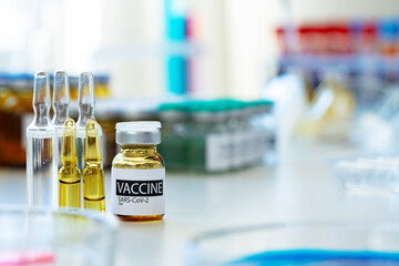 Vaccine in vial for injection on table against background of laboratory