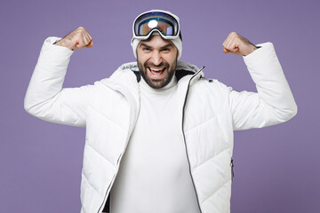 Strong skier man in white windbreaker jacket ski goggles mask showing biceps muscles spend extreme...