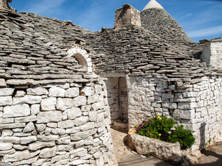 Tradtional white houses in Trulli village. Alberobello, Italy. The style of construction is...