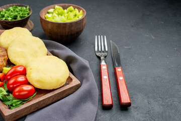 Tasty cutlets chopped vegetables greens on dark background