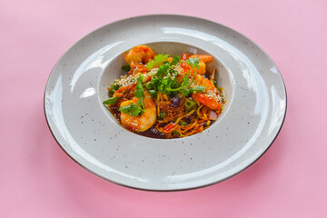 Asian noodles with shrimps, asparagus and sesame seeds. Delicious shrimp wog, traditional Asian cuisine.