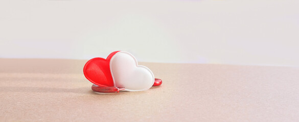 steel shabby  carabiner holding  two white and red hearts as symbol of strong love,