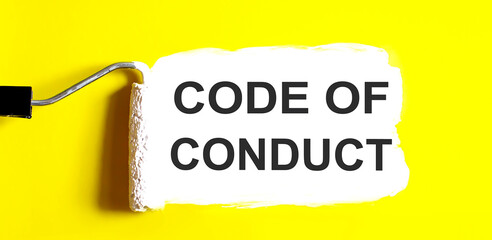 CODE OF CONDUCT One open can of paint with white brush on it on yellow background. Top view. Repairing concept.
