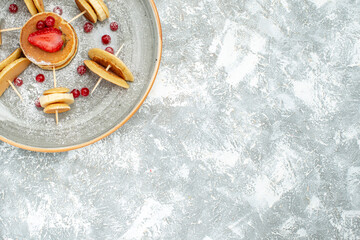 Close up view of fruit pancake decoration for breakfast on a white plate and white background