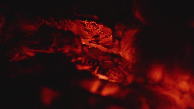 Smoldering wood in the village stove. Heat from a dying fire. Close up. Soft focus