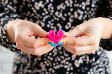Woman folding menstrual cup in hands close up