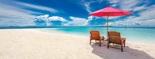 Beautiful tropical beach scenery. sun beds, loungers, umbrella under palm tree. White sand, sea...
