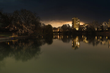 Lietzensee Park with adjacent buildings in the Berlin capital district of Charlottenburg on a winter December evening. - obrazy, fototapety, plakaty
