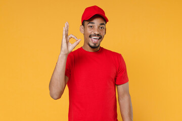 Fototapeta premium Delivery employee african man in red cap blank print t-shirt uniform workwear work courier service on quarantine covid-19 virus concept isolated on yellow background studio. Tattoo translation life.