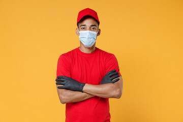 Delivery employee african man in red cap blank print t-shirt face mask gloves uniform work courier dealer service on quarantine coronavirus covid-19 virus concept isolated on yellow background studio.