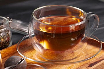Glass cup of tea on wooden board
