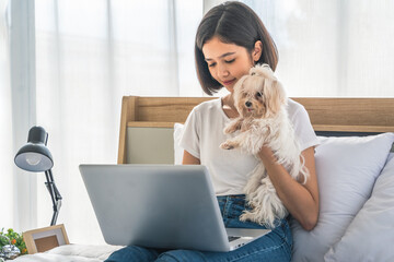 woman work at home and playing with her dogs in bedroom in apartment