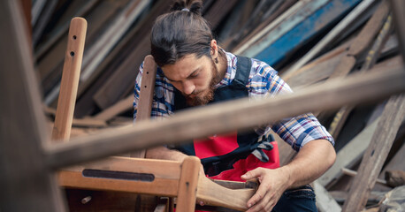 carpenter sand woodwork with sandpaper in furniture workshop