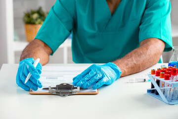 Close up of doctor's hands making notes on table