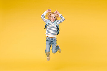 Full length of joyful male boy 10s years old in striped sweatshirt eyeglasses backpack jumping...