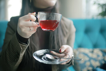 girl in a cafe drinking tea / a modern cafe, a young adult model drinking tea and holding a cup in her hand