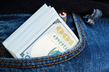 large wad of hundred-dollar bills protrudes from pocket of jeans. Concept of cash bribery. All...