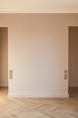 Modern and bright interior of  empty cream-colored room with herringbone parquet floor