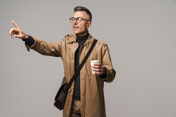 Handsome man wearing stylish coat posing isolated