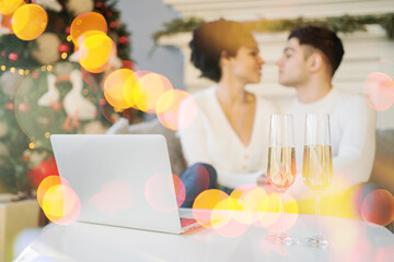 a new year's card, glasses of champagne are on a white table and a laptop. In the background, a Christmas tree with a garland and a couple in love are sitting on the sofa, celebrating the holiday.