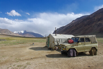 Kyrgyz nomad camp with tent and car along the Pamir Highway in high-altitude summer pasture between Ak Baital pass and Karakul lake in Murghab district, Gorno-Badakshan, Tajikistan