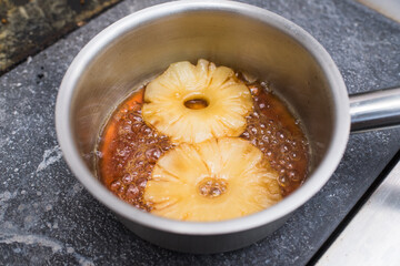 The chef prepares pineapples soaked in delicious sweet caramel