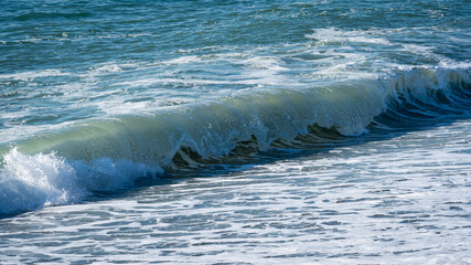 Naklejka premium Blue green sea waves near shore. Close-up. Foamed seawater in waves of traditional color. Atmosphere of calm serenity. Perfect backdrop for relaxation theme. Elegant nature concept for design.