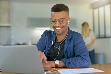 mixed-raced young man working from home on laptop