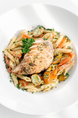 fried chicken breast with penne and saute vegetables pasta dish