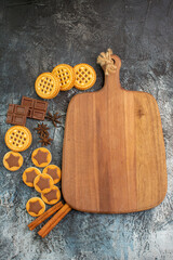 wooden platter with different cookies on grey ground