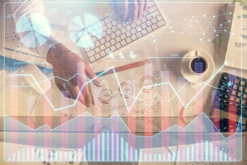 Multi exposure of man's hands typing over computer keyboard and forex graph hologram drawing. Top view. Financial markets concept.