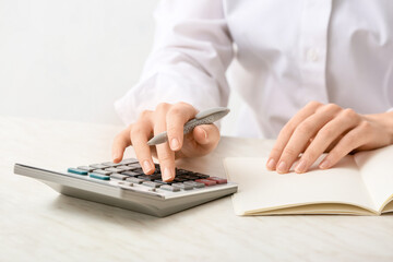 Female accountant with calculator working in office