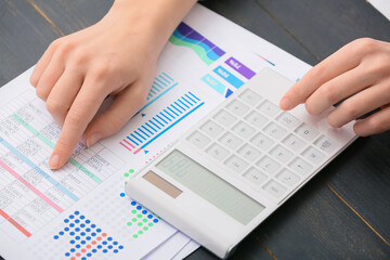 Female accountant with calculator working in office, closeup
