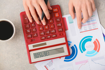 Female accountant with calculator working in office, top view