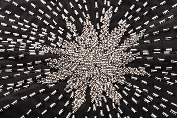 Close up star of silver beads on black fabric