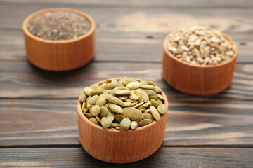 Pumpkin seeds, chia, sunflowers seeds in bowl on brown background