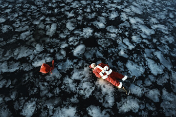 Santa Claus skating on the ice of the lake, slipped, lies down, Santa loser